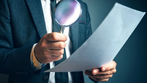 A man holds a magnifying glass