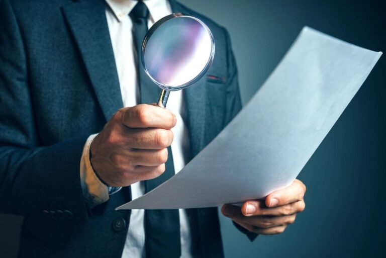 A man holds a magnifying glass