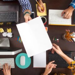 A sheet of paper is being passed between team members.