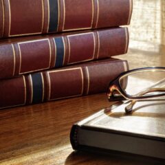 Law books with reading glasses symbolizing legal knowledge and compliance in marketin.
