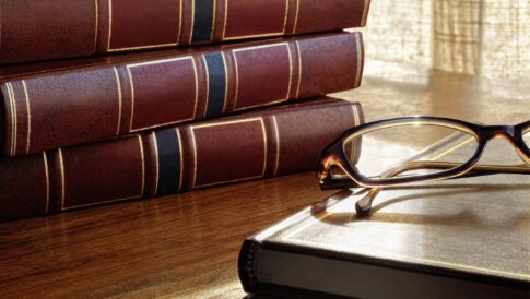 Law books with reading glasses symbolizing legal knowledge and compliance in marketin.