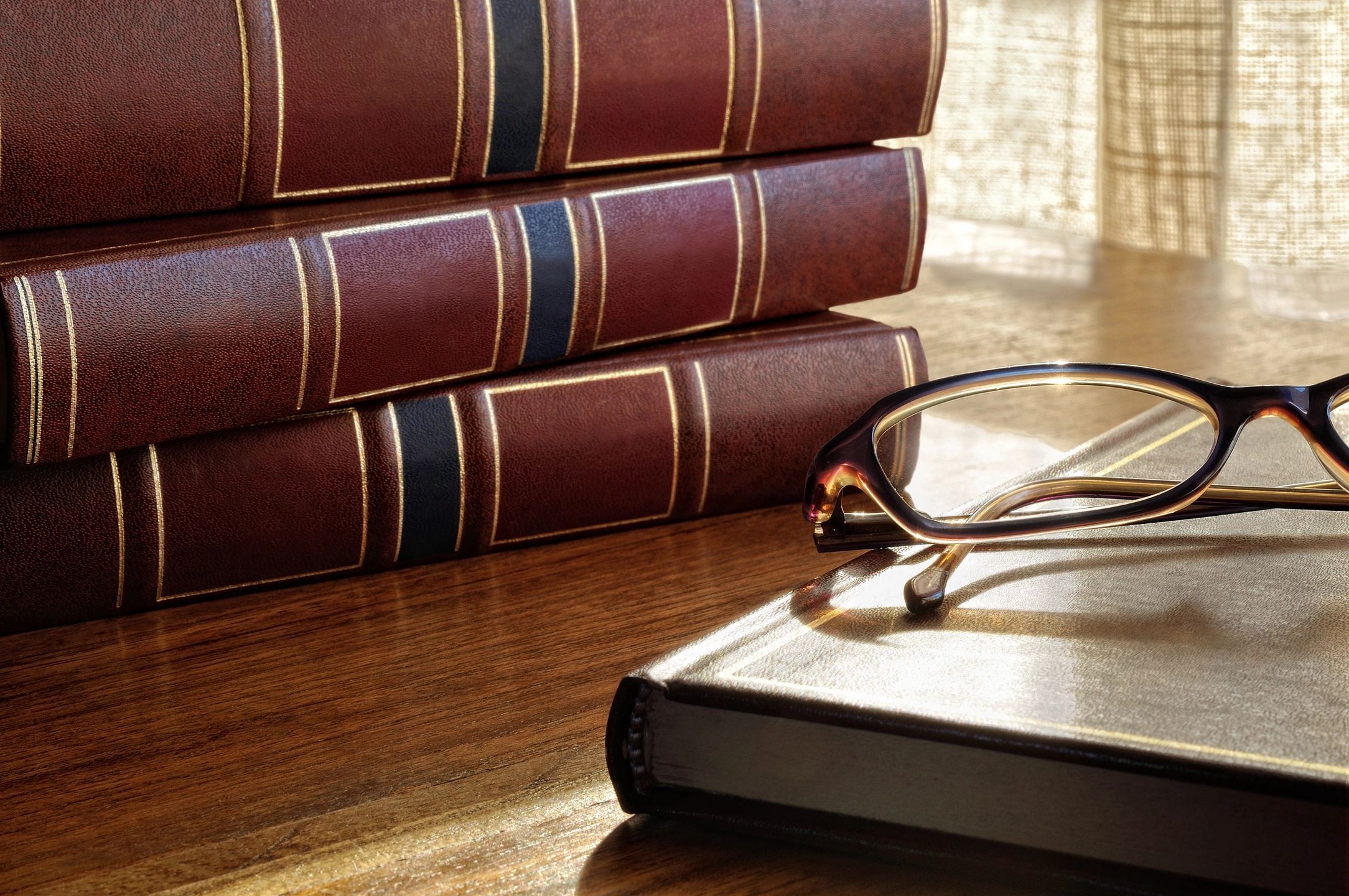 Law books with reading glasses symbolizing legal knowledge and compliance in marketin.